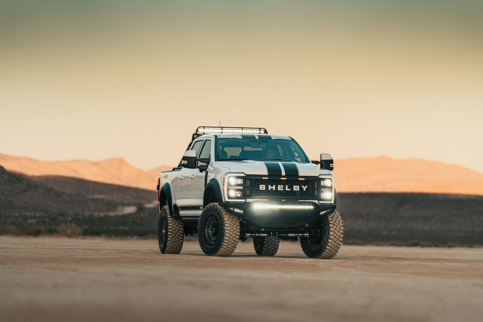 2024 Ford F-250 Shelby Super Baja driving in the desert at sunset